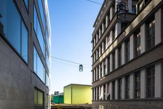 Durchblick zwischen dem alten Postgebäude und dem Neubau auf das Gelände der Schweizerischen Bundesbahn.