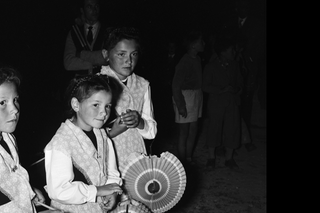 schwarz-weisses Foto von drei Mädchen mit Lampions an einem Fackelzug