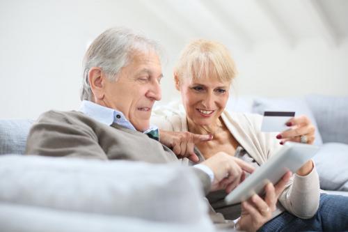 женщина учит старика пользоваться интернет-системой платежей
